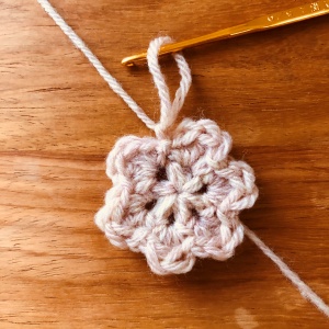 かぎ針編み、花のモチーフが出来上がり、最後の糸を引き抜く
