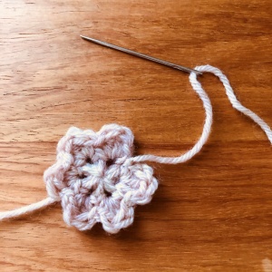 かぎ針編みの花のモチーフ、糸処理のためとじ針に糸を通している